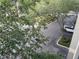 Balcony view overlooking manicured landscaping, a parking area and a white car at 716 Seagate Dr # 716, Tampa, FL 33602