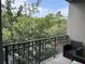 Private balcony with a view of lush trees and a chair at 716 Seagate Dr # 716, Tampa, FL 33602