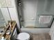 Bright bathroom features a tub/shower combo with glass door, granite vanity top, and neutral tile flooring at 716 Seagate Dr # 716, Tampa, FL 33602