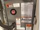 Close-up view of an air conditioner unit with various labels, safety warnings, and a Rheem logo at 716 Seagate Dr # 716, Tampa, FL 33602