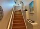 Stairway with hardwood floors leading upwards to the second floor featuring decorative shelving and a white banister at 716 Seagate Dr # 716, Tampa, FL 33602