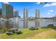 Picturesque waterfront with boat, buildings, picnic tables, and lush greenery in the background at 716 Seagate Dr # 716, Tampa, FL 33602