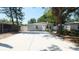 Inviting single-story home featuring a spacious driveway, a basketball hoop, and lush trees at 7428 36Th N Ave, St Petersburg, FL 33710