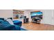 Comfortable living room featuring hardwood floors, a cozy blue sofa, and large TV with views of the mountain at 7428 36Th N Ave, St Petersburg, FL 33710