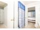 Bright bathroom leading to the bedroom, featuring tiled floors and a shower with blue accents at 7812 Turnbridge Dr, Port Richey, FL 34668