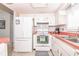 Efficient kitchen featuring white appliances, tile backsplash, and a convenient layout at 7812 Turnbridge Dr, Port Richey, FL 34668