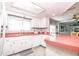 Well-maintained kitchen with white cabinetry, a breakfast bar, and plenty of counter space at 7812 Turnbridge Dr, Port Richey, FL 34668