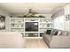 Inviting living room featuring built-in shelving, comfortable seating, and a ceiling fan for added comfort at 7812 Turnbridge Dr, Port Richey, FL 34668