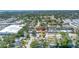 An aerial view of the home in its neighborhood showcases nearby shops and mature trees at 8130 129Th N Ln, Seminole, FL 33776