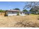 View of the home's backyard featuring a small patio and partially fenced-in yard with grass at 8130 129Th N Ln, Seminole, FL 33776