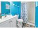 Bright bathroom featuring a white vanity, toilet, and shower with a blue and white patterned curtain at 8130 129Th N Ln, Seminole, FL 33776