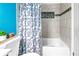 Bathtub and shower with tile surround and stylish leaf shower curtain at 8130 129Th N Ln, Seminole, FL 33776