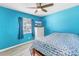 Blue bedroom featuring a window, light wood flooring, a ceiling fan, and a comfortable bed at 8130 129Th N Ln, Seminole, FL 33776