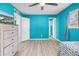 Spacious blue bedroom with wood floors, ample closet space, ceiling fan, and natural lighting at 8130 129Th N Ln, Seminole, FL 33776