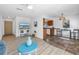 Open-concept living room and kitchen area with tile and wood flooring and a peninsula with bar seating at 8130 129Th N Ln, Seminole, FL 33776
