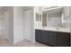 Bathroom featuring double sinks with grey cabinets and a walk-in shower at 8408 Nuzum Rd, Brooksville, FL 34613
