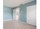 A light blue bedroom with tiled floor and closet and doorway that lets in plenty of light at 8408 Nuzum Rd, Brooksville, FL 34613