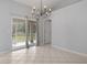 Dining area featuring sliding glass doors to a screen enclosed patio, chandelier, and tile floors at 8408 Nuzum Rd, Brooksville, FL 34613