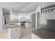 Spacious kitchen with white cabinets, stainless steel oven, island with double sink, and grey countertops at 8408 Nuzum Rd, Brooksville, FL 34613