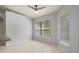 Bright living room with a ceiling fan, tile floors, and large windows with blinds at 8408 Nuzum Rd, Brooksville, FL 34613
