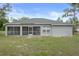 Rear view of the house featuring a screened lanai and neutral paint at 8408 Nuzum Rd, Brooksville, FL 34613