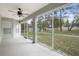 Large screened porch with ceiling fan and view to the trees and backyard at 8408 Nuzum Rd, Brooksville, FL 34613