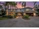 Beautiful two-story home with lush landscaping, a brick driveway, and a two-car garage surrounded by tall palm trees at 8488 35Th N Ave, St Petersburg, FL 33710