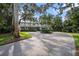 Stately home with a circular driveway, lush landscaping, and mature trees providing shade and privacy at 8488 35Th N Ave, St Petersburg, FL 33710
