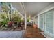 Inviting front porch with cozy seating, beautiful flooring, and lush landscaping creating a relaxing outdoor space at 8488 35Th N Ave, St Petersburg, FL 33710
