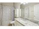 Bathroom featuring marble countertop, modern shower curtain and ample lighting at 10260 Devonshire Lake Dr, Tampa, FL 33647