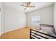 Bright bedroom with wood floors, twin bed, window with blinds, and ceiling fan at 10260 Devonshire Lake Dr, Tampa, FL 33647