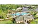 Aerial view of community pool, playground, and lake, surrounded by lush landscaping at 10260 Devonshire Lake Dr, Tampa, FL 33647