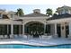 Community pool area with ample seating and umbrellas for relaxing by the water at 10260 Devonshire Lake Dr, Tampa, FL 33647