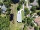Aerial view of the gray roof of a two-story home surrounded by trees, lawns, and a lengthy driveway at 1033 Hammock Cir, Tarpon Springs, FL 34688