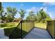 Wood back deck with black metal railings overlooking a grassy backyard at 1033 Hammock Cir, Tarpon Springs, FL 34688