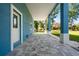 Covered porch with large columns and pavers provides a shady spot at 1033 Hammock Cir, Tarpon Springs, FL 34688