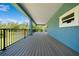 Covered porch has railing with view of pool and mature trees at 1033 Hammock Cir, Tarpon Springs, FL 34688