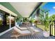 Large covered balcony with seating, dining, potted plants, and great outdoor space for entertaining at 1033 Hammock Cir, Tarpon Springs, FL 34688