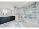 The bathroom features double vanities, marble tile flooring, soaking tub, and a glass shower at 1033 Hammock Cir, Tarpon Springs, FL 34688