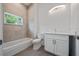 Bathroom featuring modern vanity, tiled shower-tub combo and neutral color palette at 1033 Hammock Cir, Tarpon Springs, FL 34688