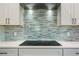 Close-up of a cooktop and stainless steel vent hood over the white countertop at 1033 Hammock Cir, Tarpon Springs, FL 34688