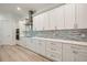 Bright kitchen featuring a stainless steel vent hood, tile backsplash, and white cabinets at 1033 Hammock Cir, Tarpon Springs, FL 34688