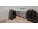 Spacious laundry room boasts modern appliances and grey cabinets with a quartz countertop at 1033 Hammock Cir, Tarpon Springs, FL 34688