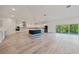 Open floor plan with kitchen, stainless steel appliances, and living room with balcony access at 1033 Hammock Cir, Tarpon Springs, FL 34688