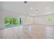 Living room with access to the balcony, neutral paint, and luxury vinyl flooring at 1033 Hammock Cir, Tarpon Springs, FL 34688