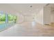 Living room with balcony access, neutral paint, luxury vinyl flooring and lots of windows at 1033 Hammock Cir, Tarpon Springs, FL 34688