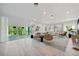 Expansive living room with ample natural light, wood floors, and access to a balcony at 1033 Hammock Cir, Tarpon Springs, FL 34688