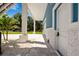 Covered side patio with gray stone flooring and white columns at 1033 Hammock Cir, Tarpon Springs, FL 34688