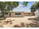 Rear view of house and a mostly bare yard with sparse ground cover and small privacy fence at 10817 Kingsbridge Rd, Port Richey, FL 34668