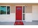 Close-up of the bright red front door with security features and an inviting welcome mat at 10817 Kingsbridge Rd, Port Richey, FL 34668